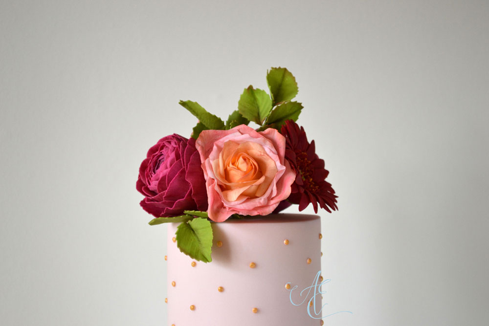 closer gold polka dot top tier with vibrant sugar flowers