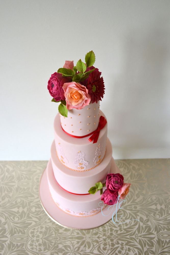 pink wedding cake with vibrant sugar flowers aerial shot