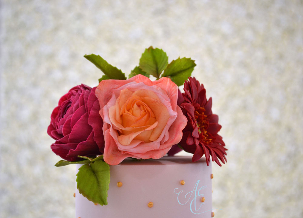 Close up top tier with vibrant sugar flower bouquet