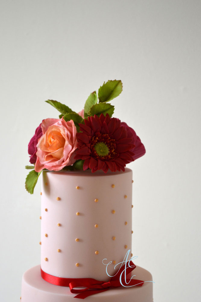 vibrant sugar flower bouquet on top tier of wedding cake