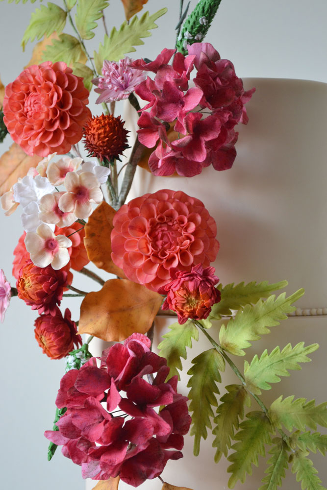 vibrant sugar flowers and ferns in crimson coral amber burnt orange chartreuse