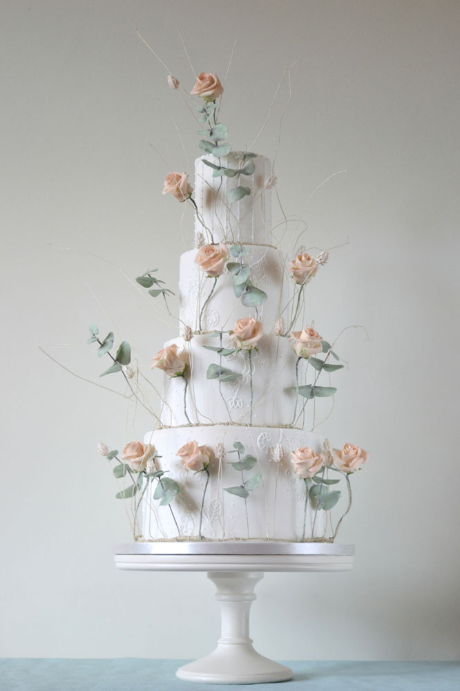 Rings of sugar roses foliage and grasses wedding cake