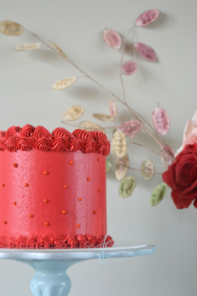 Scarlett red with orange polka dots piped vintage cake close up